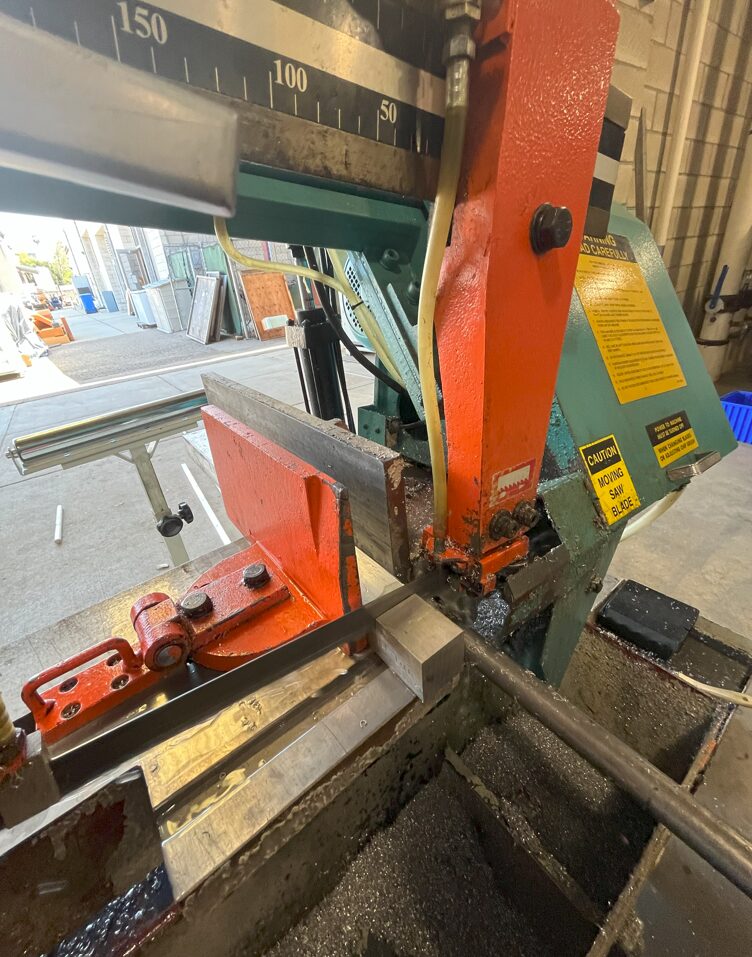 Bandsaw cutting an aluminum blank to length